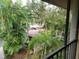 Balcony view of lush landscaping and a parking area at 642 Bird Bay E Dr # 205, Venice, FL 34285