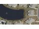 Aerial view of a home backing to a beautiful pond with fountain feature, in a residential community at 906 Bluewater Dr, Sun City Center, FL 33573