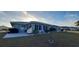 Backyard view of the house exterior and patio area surrounded by lawn at 906 Bluewater Dr, Sun City Center, FL 33573