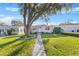 Charming house with a tree-lined walkway and landscaping at 5129 17Th N St, St Petersburg, FL 33714