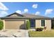Tan one-story house with a two-car garage and landscaping at 922 Wynnmere Walk Ave, Ruskin, FL 33570