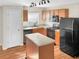 Modern kitchen with wood cabinets, island, and black appliances at 922 Wynnmere Walk Ave, Ruskin, FL 33570