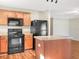 Kitchen with wood cabinets, island, and black appliances at 922 Wynnmere Walk Ave, Ruskin, FL 33570
