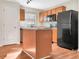 Modern kitchen featuring wood cabinets, an island, and black appliances at 922 Wynnmere Walk Ave, Ruskin, FL 33570