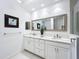 Double vanity bathroom with a large mirror and white cabinets at 10530 Boardwalk Loop # 304, Lakewood Ranch, FL 34202