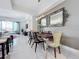 Bright dining room featuring a wooden dining table, modern light fixture, and decorative mirrors on the wall at 10530 Boardwalk Loop # 304, Lakewood Ranch, FL 34202