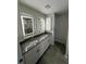 Bathroom featuring dual sinks, granite countertops, and modern lighting at 10922 Brightleaf Ct, Riverview, FL 33569