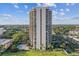 Aerial view of a modern condo building featuring a pool, lush landscaping, and city views at 2413 Bayshore Blvd # 1404, Tampa, FL 33629