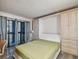 Bedroom featuring a murphy bed, neutral decor, and a private balcony overlooking the neighborhood at 2413 Bayshore Blvd # 1404, Tampa, FL 33629