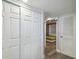 Hallway with gray wood floors, white bi-fold doors, access to the bathroom, and entrance to a bedroom at 2413 Bayshore Blvd # 1404, Tampa, FL 33629