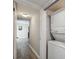 Hallway view with light grey walls, grey wood-look flooring, and a stacked washer and dryer unit at 2413 Bayshore Blvd # 1404, Tampa, FL 33629