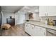 Open kitchen layout with granite countertops, white cabinets, stainless steel appliances, and a view of the hallway entrance at 2413 Bayshore Blvd # 1404, Tampa, FL 33629