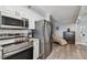 Modern kitchen with stainless steel appliances, white cabinets, and wood-look flooring adjacent to cozy seating area at 2413 Bayshore Blvd # 1404, Tampa, FL 33629