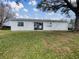 House exterior showcasing a large backyard and sliding glass doors at 8381 Chelsea Ct, North Port, FL 34287