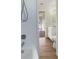 Bathroom with white tile, bathtub, and view to living area at 8381 Chelsea Ct, North Port, FL 34287