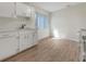 Efficient kitchen featuring white cabinets and wood-look floors at 8381 Chelsea Ct, North Port, FL 34287
