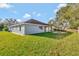 House exterior with grassy backyard and firepit at 2443 Waterfall Dr, Spring Hill, FL 34608