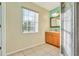 Bathroom with wood cabinets, shower, and a window at 2443 Waterfall Dr, Spring Hill, FL 34608