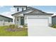 Charming two-story home featuring a two-car garage, modern design elements, and a well-manicured front yard at 14044 Crutchfield Ct, Parrish, FL 34219