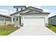 Two-story home with a light gray facade, complemented by a two-car garage and simple landscaping at 14044 Crutchfield Ct, Parrish, FL 34219