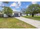 Charming house with a gray garage door and well-maintained yard at 1845 Skyland Dr, Clearwater, FL 33759