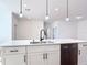 Close-up of a modern kitchen island with white cabinets, stainless steel appliances, and stylish lighting at 101 Tompkins St, Port Charlotte, FL 33954