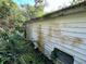 Side view of a house showing weathered siding and overgrown vegetation at 9431 Pontiac St, New Port Richey, FL 34654