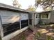 View of house exterior with open door and overgrown vegetation at 9431 Pontiac St, New Port Richey, FL 34654