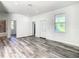 Living room with wood-look floors, an exterior door and bathroom access at 1543 Mackinaw St, North Port, FL 34286