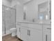 Modern bathroom featuring marble wall tiles, dual sinks, and glass shower door at 2515 Wise River Lane, Zephyrhills, FL 33539