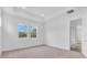 Bright bedroom with two windows offering natural light and a view of trees and a walk-in closet at 2515 Wise River Lane, Zephyrhills, FL 33539
