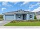 Charming one-story home featuring a blue exterior, well-manicured lawn, and a two-car garage at 2515 Wise River Lane, Zephyrhills, FL 33539