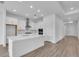 Modern kitchen with stainless steel appliances, white cabinets, a large island, and hardwood floors at 2515 Wise River Lane, Zephyrhills, FL 33539