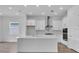 Bright kitchen with white cabinets, quartz countertops, stainless steel appliances, and large center island at 2515 Wise River Lane, Zephyrhills, FL 33539