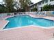 Community pool with plenty of lounge chairs for relaxation at 903 Pinellas Bayway S # 302, St Petersburg, FL 33715