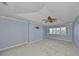 Light-filled bedroom with tray ceilings, a fan, and large windows with shutters at 903 Pinellas Bayway S # 302, Tierra Verde, FL 33715