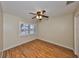 An empty bedroom with hardwood floors and a window with white shutters at 903 Pinellas Bayway S # 302, Tierra Verde, FL 33715