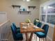 A staged dining room area featuring modern furniture, a light wood table setting, and a window with shutters at 903 Pinellas Bayway S # 302, Tierra Verde, FL 33715