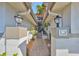 Charming walkway between units with a brick path leading to the front door, and lush plants on either side at 903 Pinellas Bayway S # 302, Tierra Verde, FL 33715