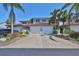 Charming townhome with a large driveway and two car garage, framed by tropical landscaping and a terracotta roof at 903 Pinellas Bayway S # 302, Tierra Verde, FL 33715