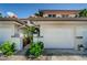 This townhome has a white garage door and a front facade framed by tropical landscaping and well maintained entryway at 903 Pinellas Bayway S # 302, Tierra Verde, FL 33715