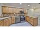 Well-lit kitchen with stainless steel appliances, granite countertops, a tile backsplash, and ample wooden cabinetry at 903 Pinellas Bayway S # 302, Tierra Verde, FL 33715