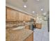 Bright kitchen featuring granite countertops, stainless steel appliances, a tile backsplash, and ample wooden cabinetry at 903 Pinellas Bayway S # 302, Tierra Verde, FL 33715