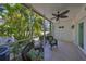 A serene screened lanai featuring comfortable seating and views of the lush tropical landscaping at 903 Pinellas Bayway S # 302, Tierra Verde, FL 33715