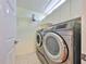 Laundry area featuring a front-loading washer and dryer with overhead storage at 903 Pinellas Bayway S # 302, Tierra Verde, FL 33715