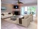 A staged living room features neutral furniture, a decorative fireplace, and sliding glass doors to a patio at 903 Pinellas Bayway S # 302, Tierra Verde, FL 33715