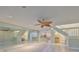 Spacious living room with tiled floors, a large mirror wall, staircase, and entry to kitchen area at 903 Pinellas Bayway S # 302, Tierra Verde, FL 33715