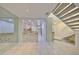 View of tiled living room showing stairs, kitchen and tiled accent wall at 903 Pinellas Bayway S # 302, Tierra Verde, FL 33715