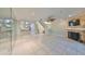 Open-concept living room showcasing tile floors, a fireplace, and a glimpse into the kitchen at 903 Pinellas Bayway S # 302, Tierra Verde, FL 33715