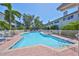 A community pool with lounge chairs and tropical landscaping at 903 Pinellas Bayway S # 302, Tierra Verde, FL 33715